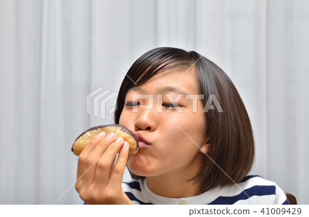 A girl who eats Eclair deliciously A girl who eats Eclair deliciously 41009429
