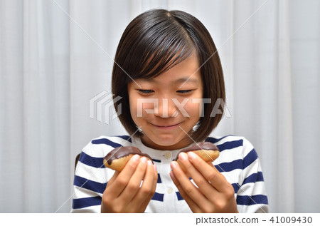 A girl who eats Eclair deliciously A girl who eats Eclair deliciously 41009430