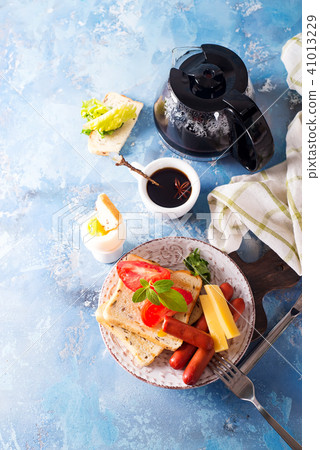 English breakfast. Fried eggs, sausages, toasts, tomatoes on stone table. 41013229