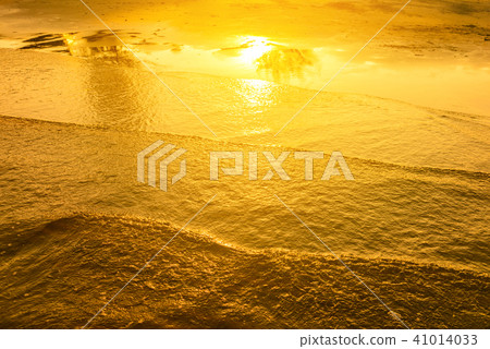 Golden light reflecting off sea water 41014033