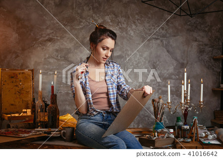Good-looking cheerful professional young female artist working on new creative project, drawing 41016642
