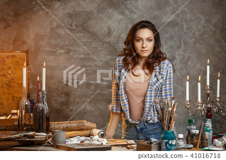 Trendy looking positive talented young aucasian woman artist relaxing after she finished her Trendy looking positive talented young aucasian woman artist relaxing after she finished her 41016718