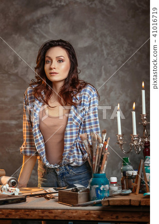 Trendy looking positive talented young aucasian woman artist relaxing after she finished her 41016719