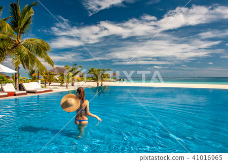 Woman with hat at beach pool in Maldives 41016965