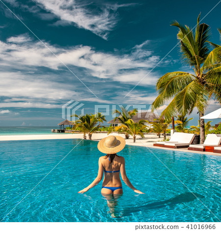 Woman with hat at beach pool in Maldives 41016966