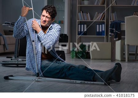 Man fell off wheelchair sitting on the floor Man fell off wheelchair sitting on the floor 41018175