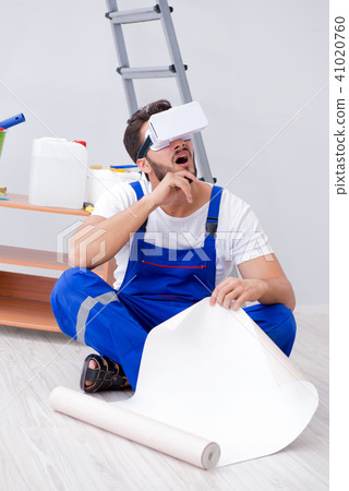 Man with VR glasses gluing wallpaper 41020760