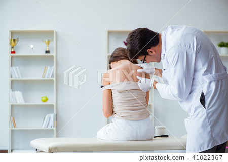 Doctor examining the skin of female patient 41022367