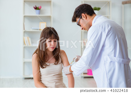 Doctor examining the skin of female patient 41022418