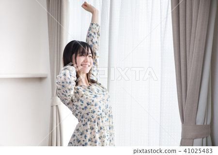 一個女孩早上醒來,伸展在窗前 一個女孩早上醒來,伸展在窗前 41025483