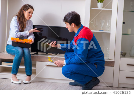 Repairman repairing tv at home 41026125