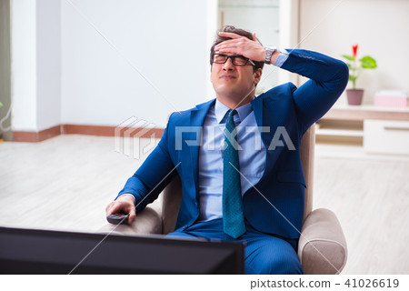 Businesman watching tv in office Businesman watching tv in office 41026619