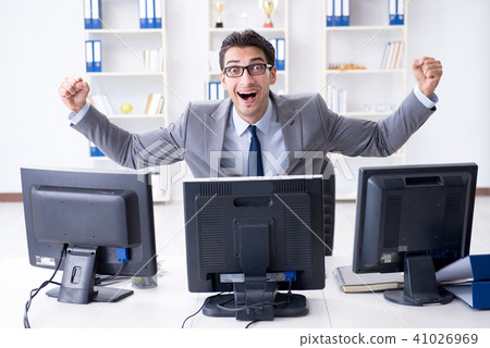 Businessman sitting in front of many screens 41026969