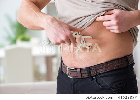 Man measuring body fat with calipers Man measuring body fat with calipers 41028857
