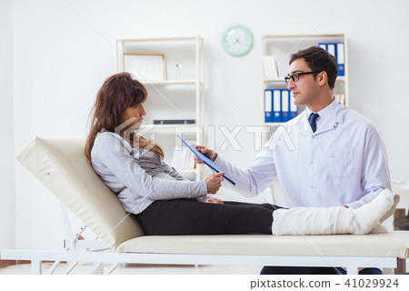 Doctor examining patient with broken leg Doctor examining patient with broken leg 41029924