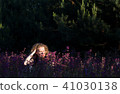 Young woman in a field with wild flowers. 41030138