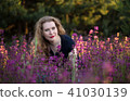Young woman in a field with wild flowers. 41030139