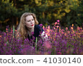 Young woman in a field with wild flowers. 41030140