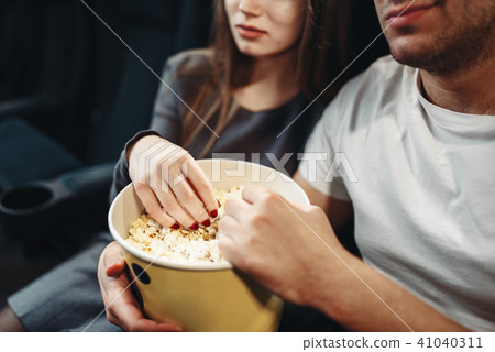 Love couple with popcorn watching movie in cinema 41040311
