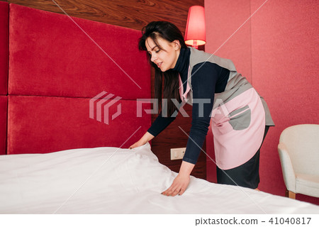 Pretty maid makes the bed in the hotel room Pretty maid makes the bed in the hotel room 41040817