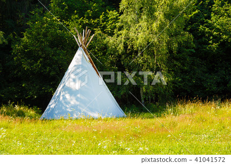 white teepee indian tent standing in beautiful summer landscape. white teepee indian tent standing in beautiful summer landscape. 41041572