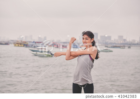 Sports concept. Beautiful girl is exercising on the beach with w 41042383