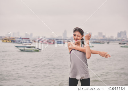 Sports concept. Beautiful girl is exercising on the beach with w 41042384
