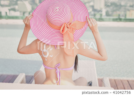Swimsuit Concept. Beautiful girl in swimsuit is applying sunscre 41042756