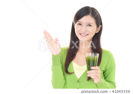 A woman holding a glass with vegetable juice A woman holding a glass with vegetable juice 41043339