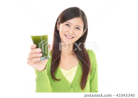 A woman holding a glass with vegetable juice A woman holding a glass with vegetable juice 41043340