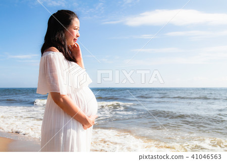 Asian pregnant women standing near the sea Asian pregnant women standing near the sea 41046563