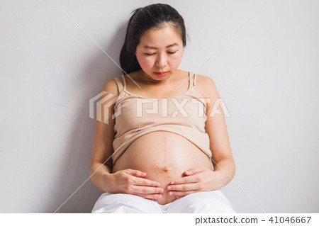 Asian pregnant women sitting on bed Asian pregnant women sitting on bed 41046667