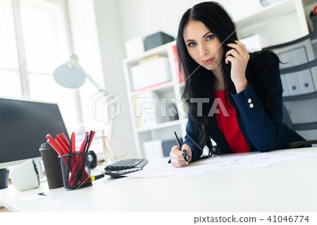 Beautiful young girl is working with documents in the office at the table and is holding a pencil in 41046774