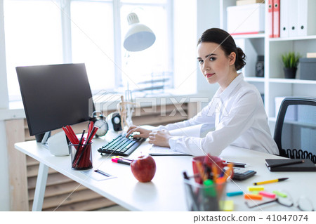 Young girl in the office working with documents at the computer. 41047074