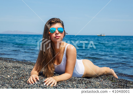 Woman sunbathing on the beach Woman sunbathing on the beach 41048001