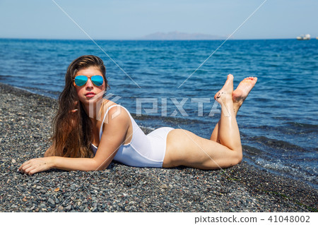 Woman sunbathing on the beach 41048002
