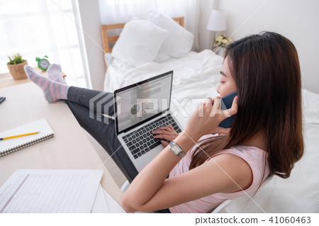 Asian female talk on mobile and see business graph 41060463