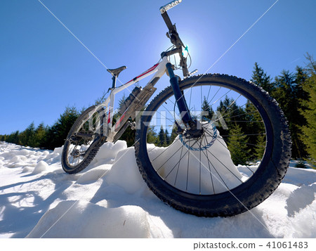 Cycling in snowy mountains on large tire wheels Cycling in snowy mountains on large tire wheels 41061483