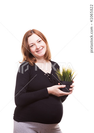 Beautiful woman holding a pot with grass and smiling to the camera Beautiful woman holding a pot with grass and smiling to the camera 41065822