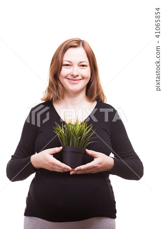 Beautiful woman holding a pot with grass and smiling to the camera Beautiful woman holding a pot with grass and smiling to the camera 41065854