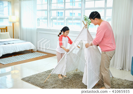 A scene in which a father and a daughter are happily resting in a tent in a living room, a tent, a love, a gift, a happiness 41065935