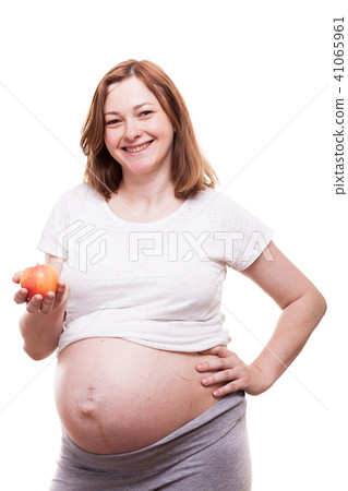 Beautiful preganant woman holding a red apple in her hands Beautiful preganant woman holding a red apple in her hands 41065961