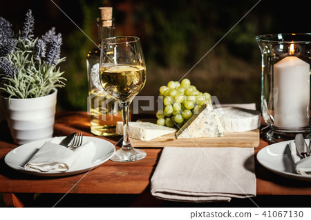 romantic dinner with a glass of wine and snacks on an old wooden table romantic dinner with a glass of wine and snacks on an old wooden table 41067130
