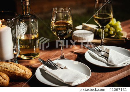 romantic dinner with a glass of wine and snacks on an old wooden table romantic dinner with a glass of wine and snacks on an old wooden table 41067181