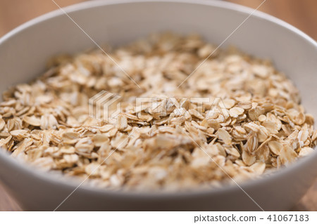 closeup oat flakes in white bowl with shallow focus closeup oat flakes in white bowl with shallow focus 41067183