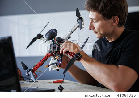 Image of engineer mending squatter sitting at table with laptop 41067339