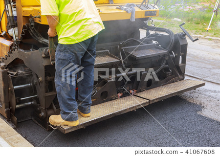 Worker on Asphalting paver machine during Road Worker on Asphalting paver machine during Road 41067608