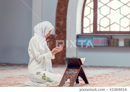 Young beautiful Muslim Woman Praying In Mosque Young beautiful Muslim Woman Praying In Mosque 41069916