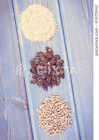 Sunflower, pumpkin and sesame seeds on boards 41070042