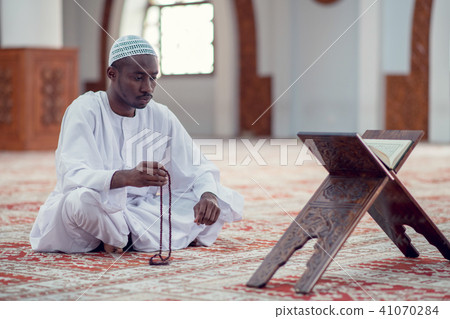 African Muslim Man Making Traditional Prayer To God While Wearing Dishdasha 41070284